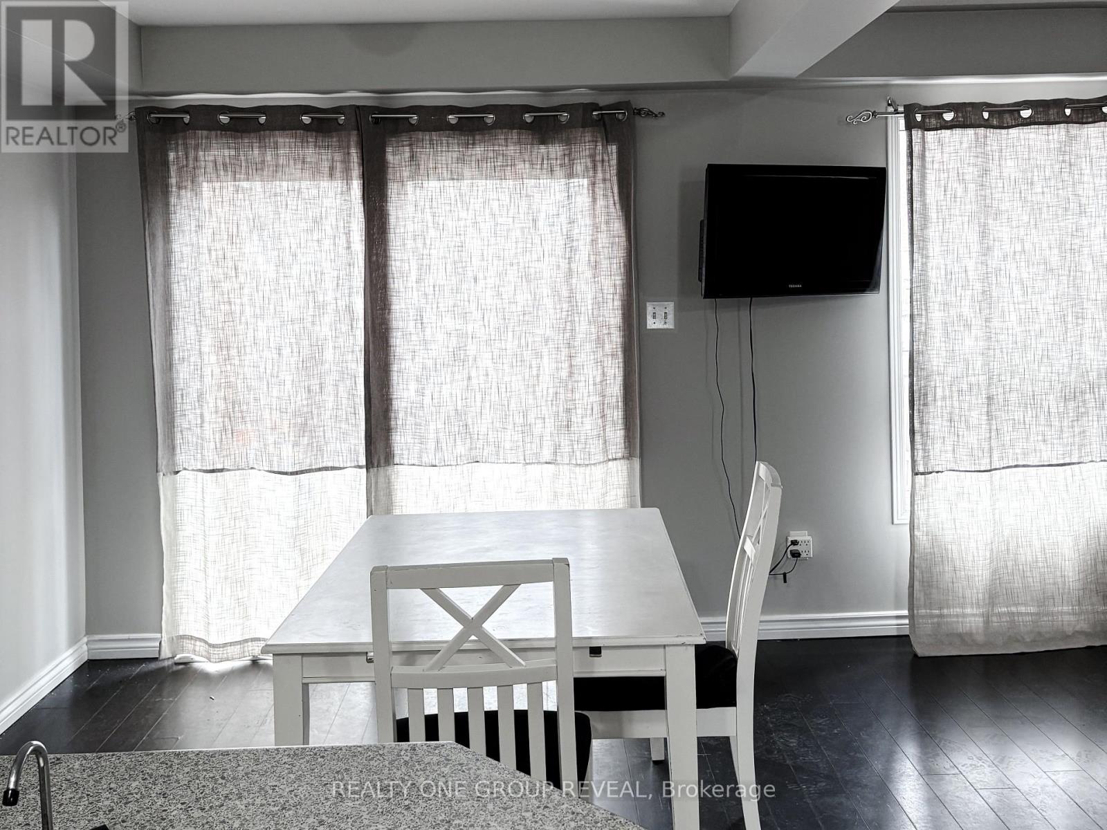 A dining room with a table and chairs.