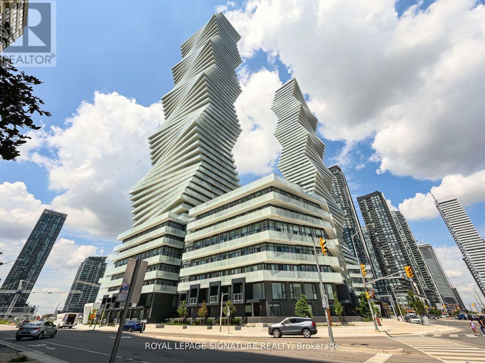 A modern building with a unique design stands out in a cityscape.