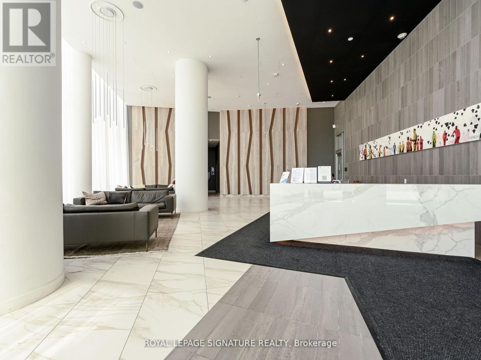 A spacious lobby with a reception desk and a large marble floor.