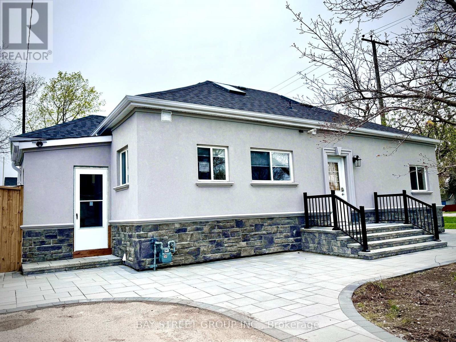 A house with a grey front and a black railing.