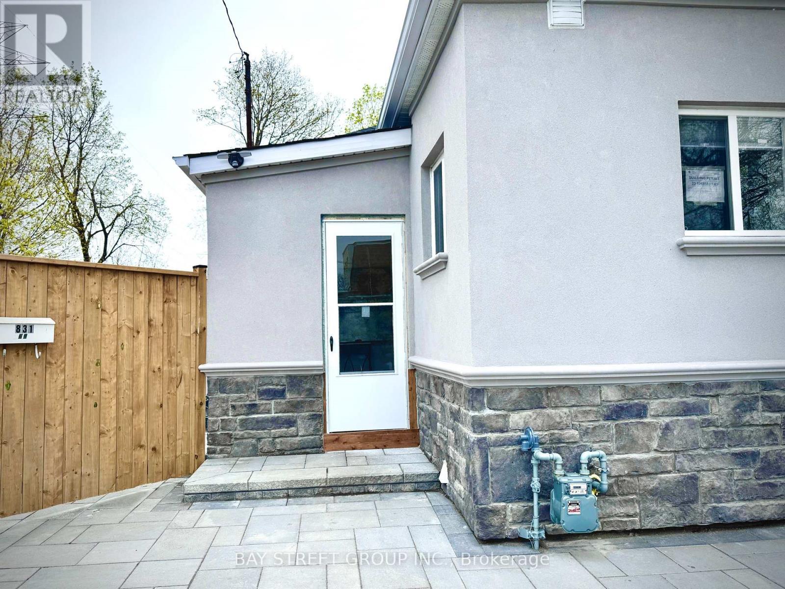 A small house with a white door and a stone base.