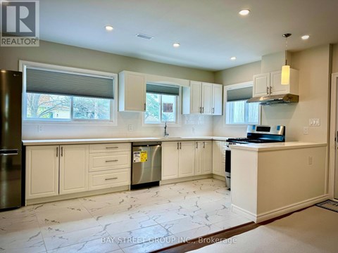 A kitchen with white cabinets and a marble floor.