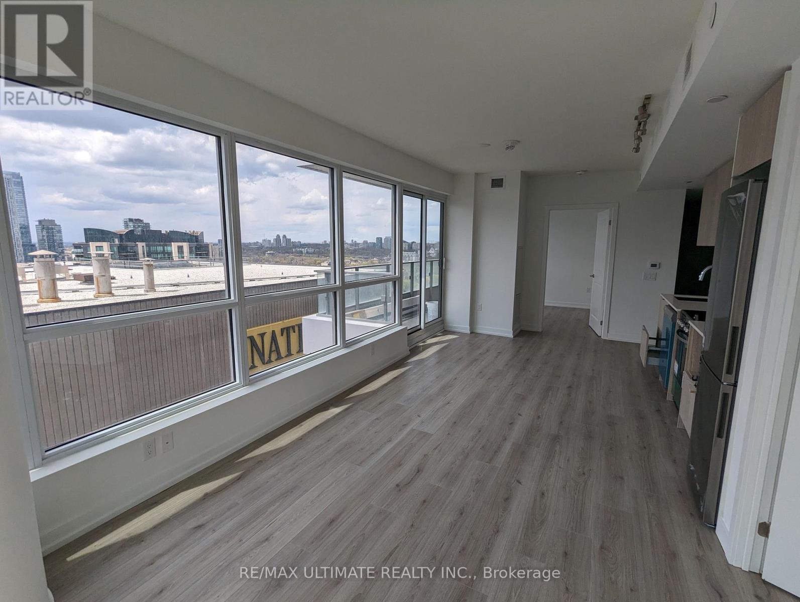 A large empty room with a view of the city through the windows.
