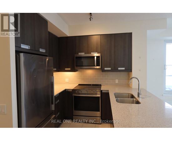 A modern kitchen with dark brown cabinets and stainless steel appliances.