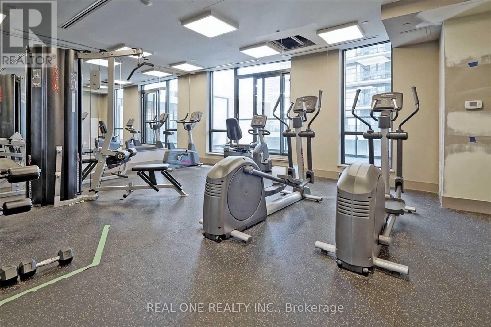 A gym with a variety of equipment including treadmills, weights, and exercise machines.