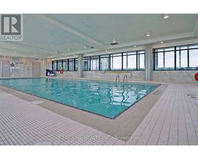 A large indoor swimming pool with a tiled floor and walls.