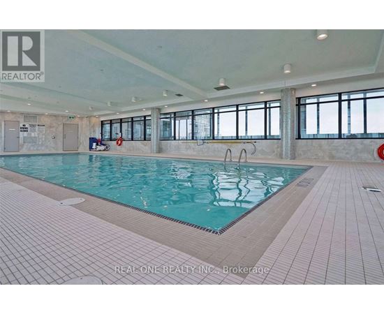 A large indoor swimming pool with a tiled floor and walls.