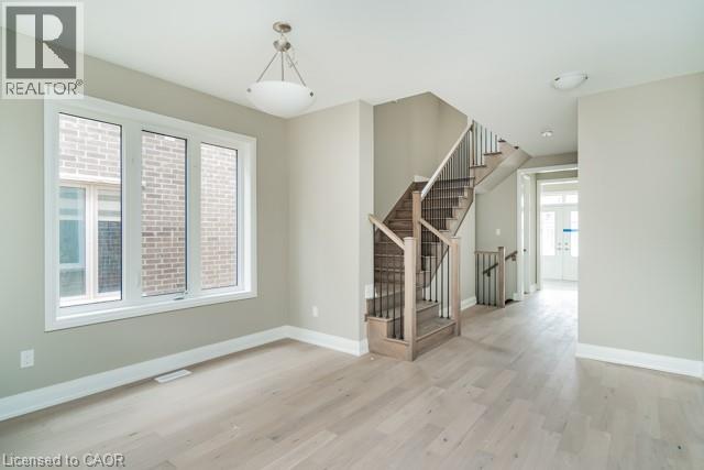 A spacious room with a staircase and a window.