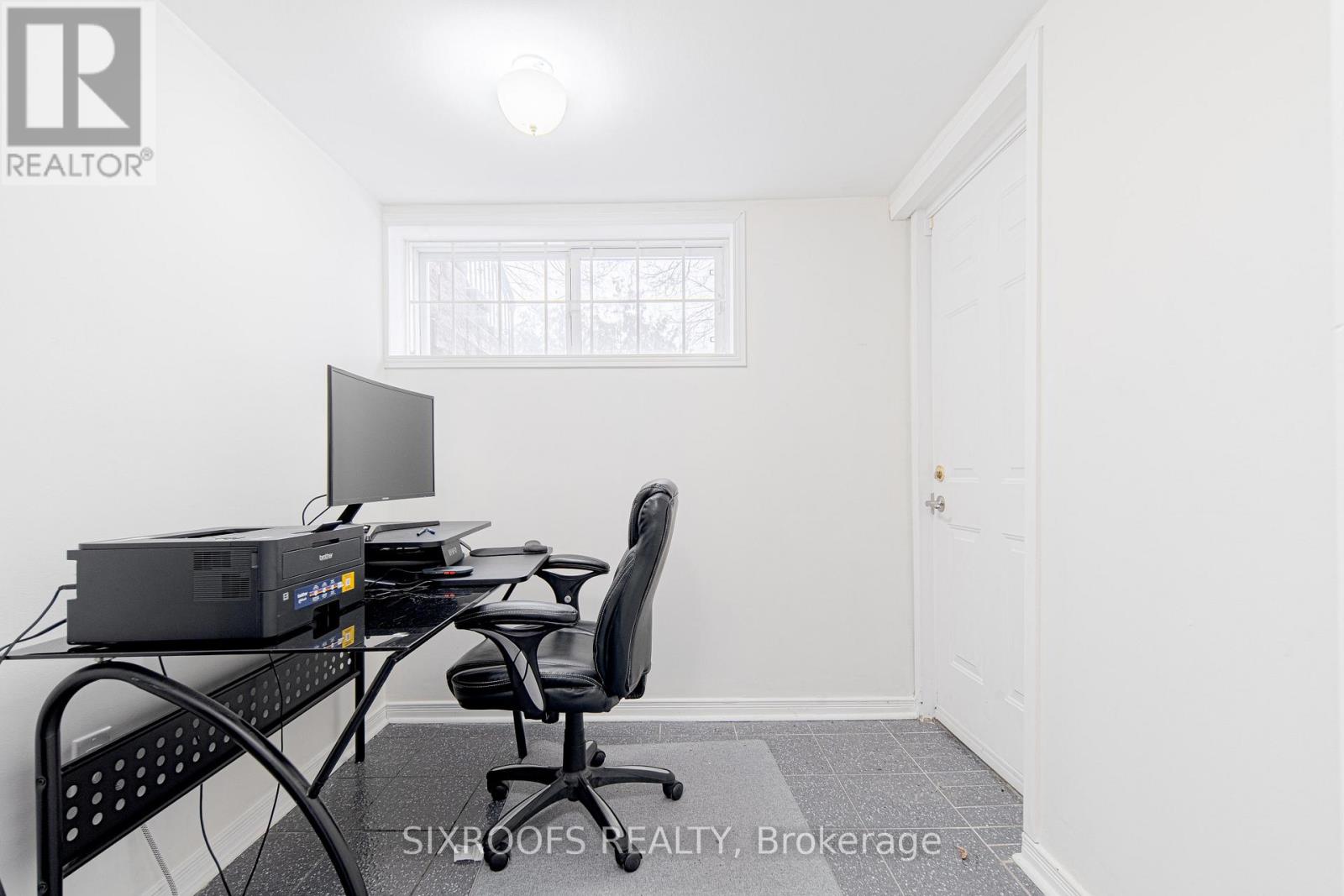 A room with a desk and a computer monitor.