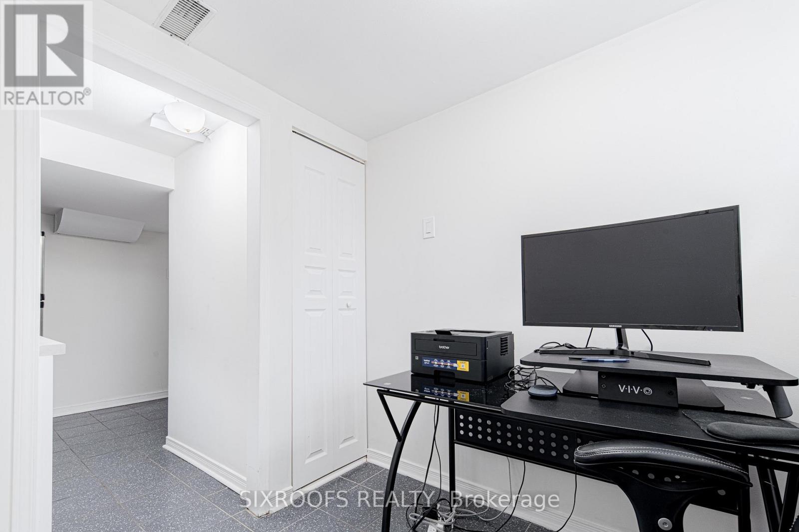 A room with a desk and a computer monitor.