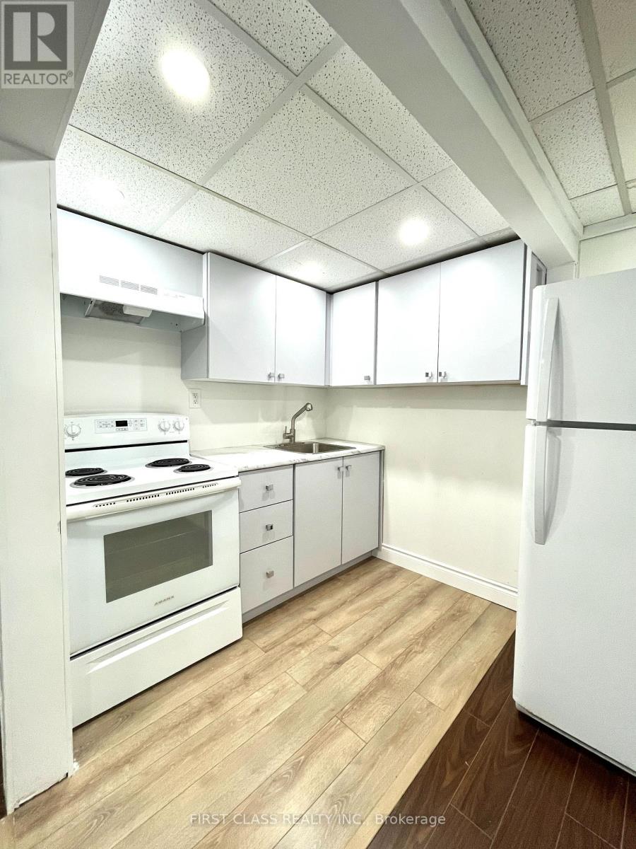 A kitchen with white appliances and wooden floors.