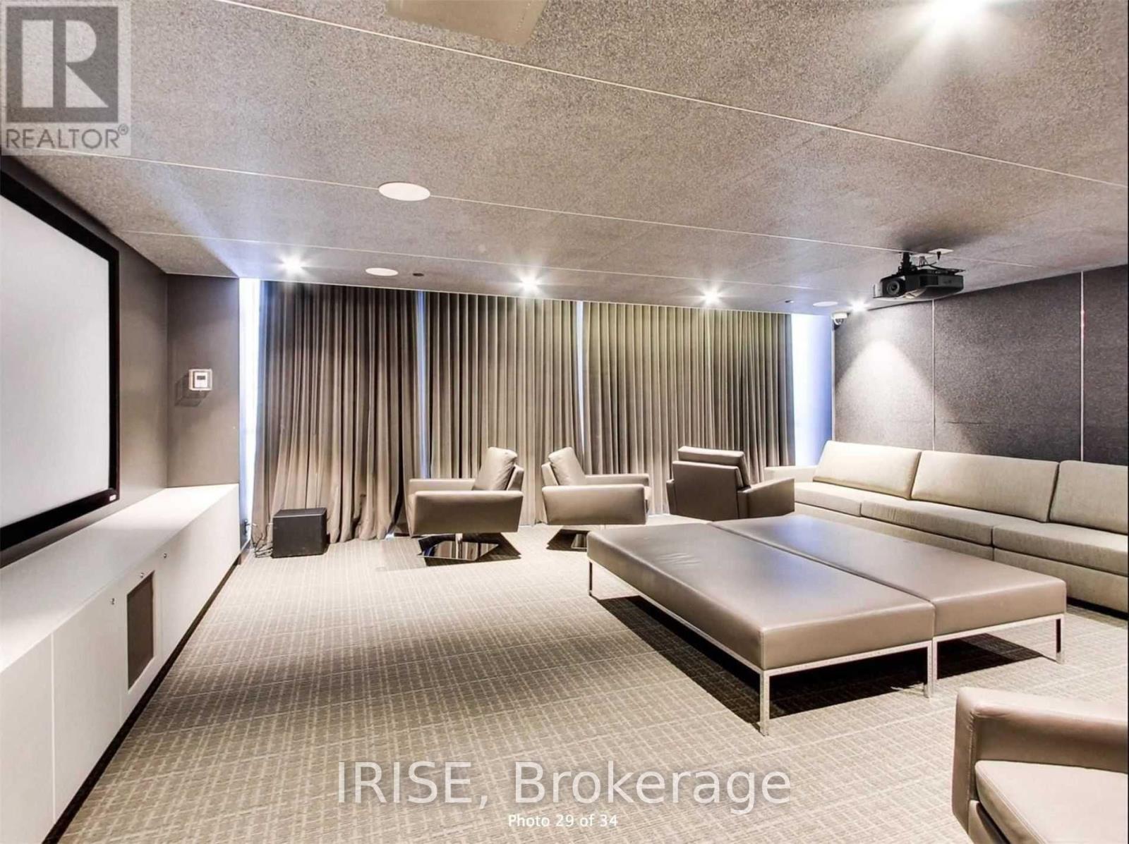 A well-lit, modern living room with a large couch and a flat-screen TV.