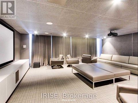 A well-lit, modern living room with a large couch and a flat-screen TV.