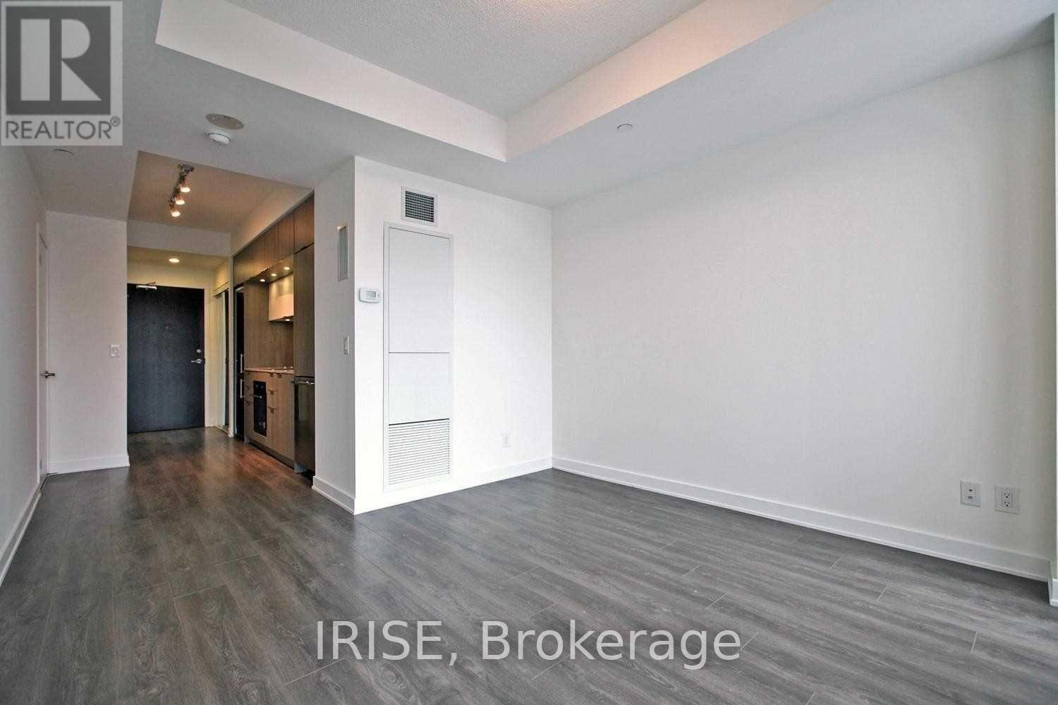 A spacious room with a door leading to another room.