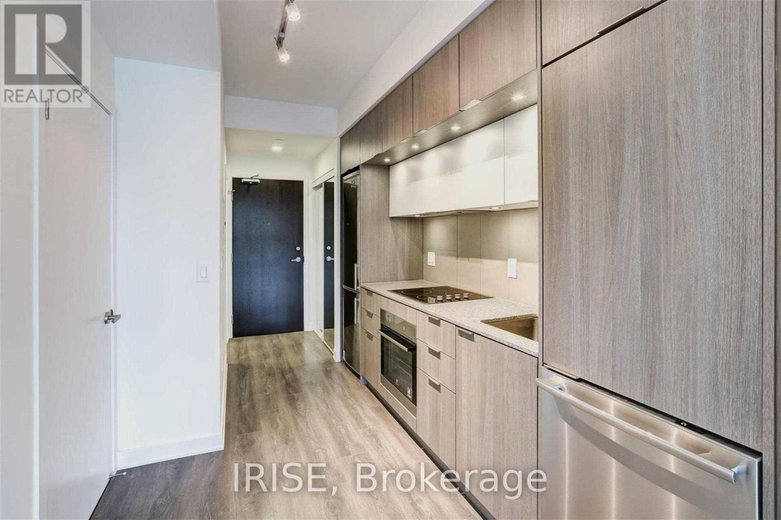 A modern kitchen with wooden cabinets and stainless steel appliances.