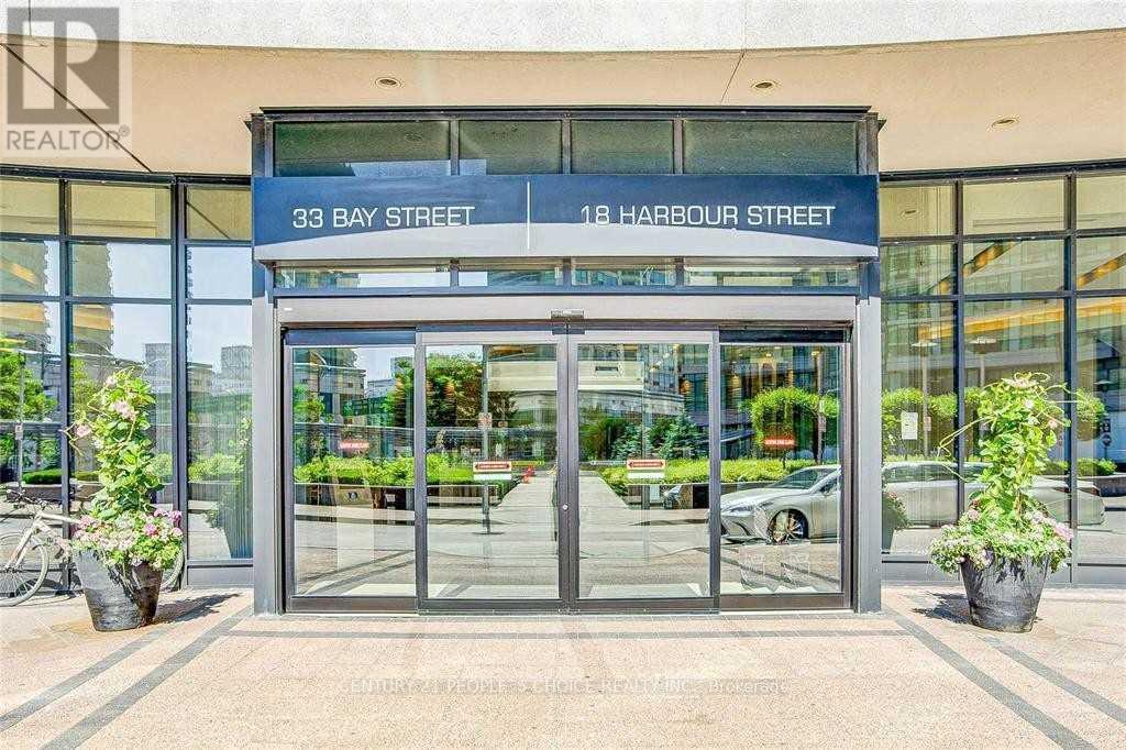 The image shows the entrance to a building with a glass door and a sign that reads "33 BAY STREET 18 HARBOUR STREET".