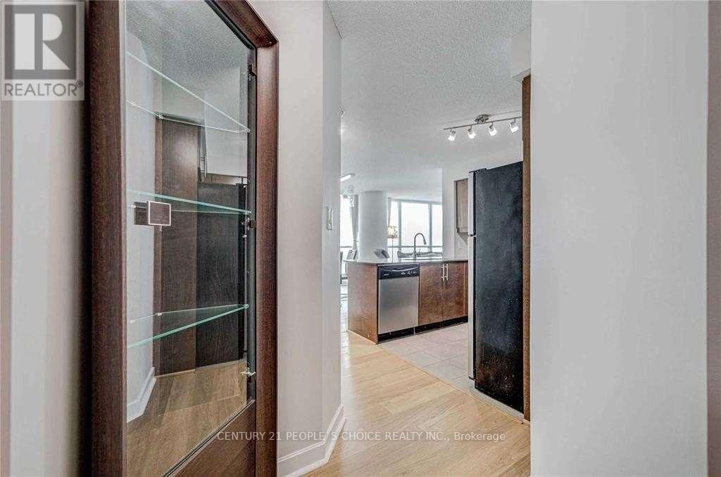 A modern kitchen with wooden floors and a glass-front cabinet.