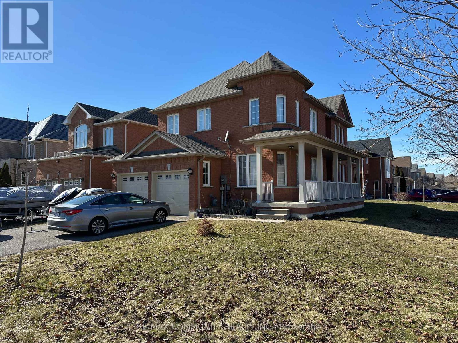 A large brick house with a car parked in front.