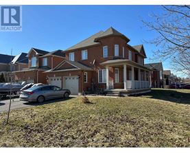 A large brick house with a car parked in front.