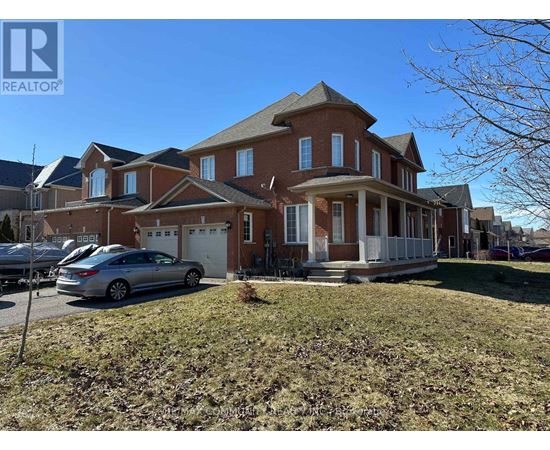 A large brick house with a car parked in front.