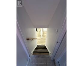A stairway leading to a doorway with a light on.