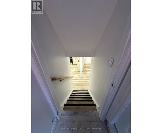 A stairway leading to a doorway with a light on.