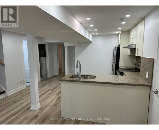 A kitchen with a sink and a refrigerator.