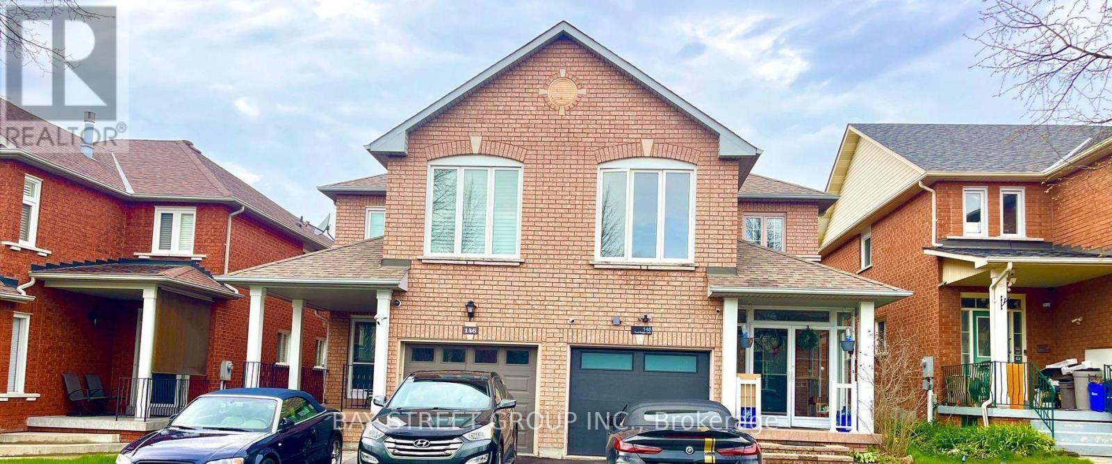 A red brick house with a black car parked in front.