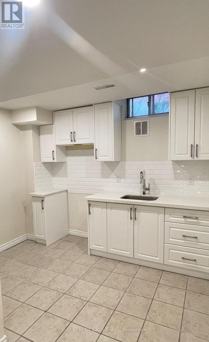 A white kitchen with a sink and cabinets.