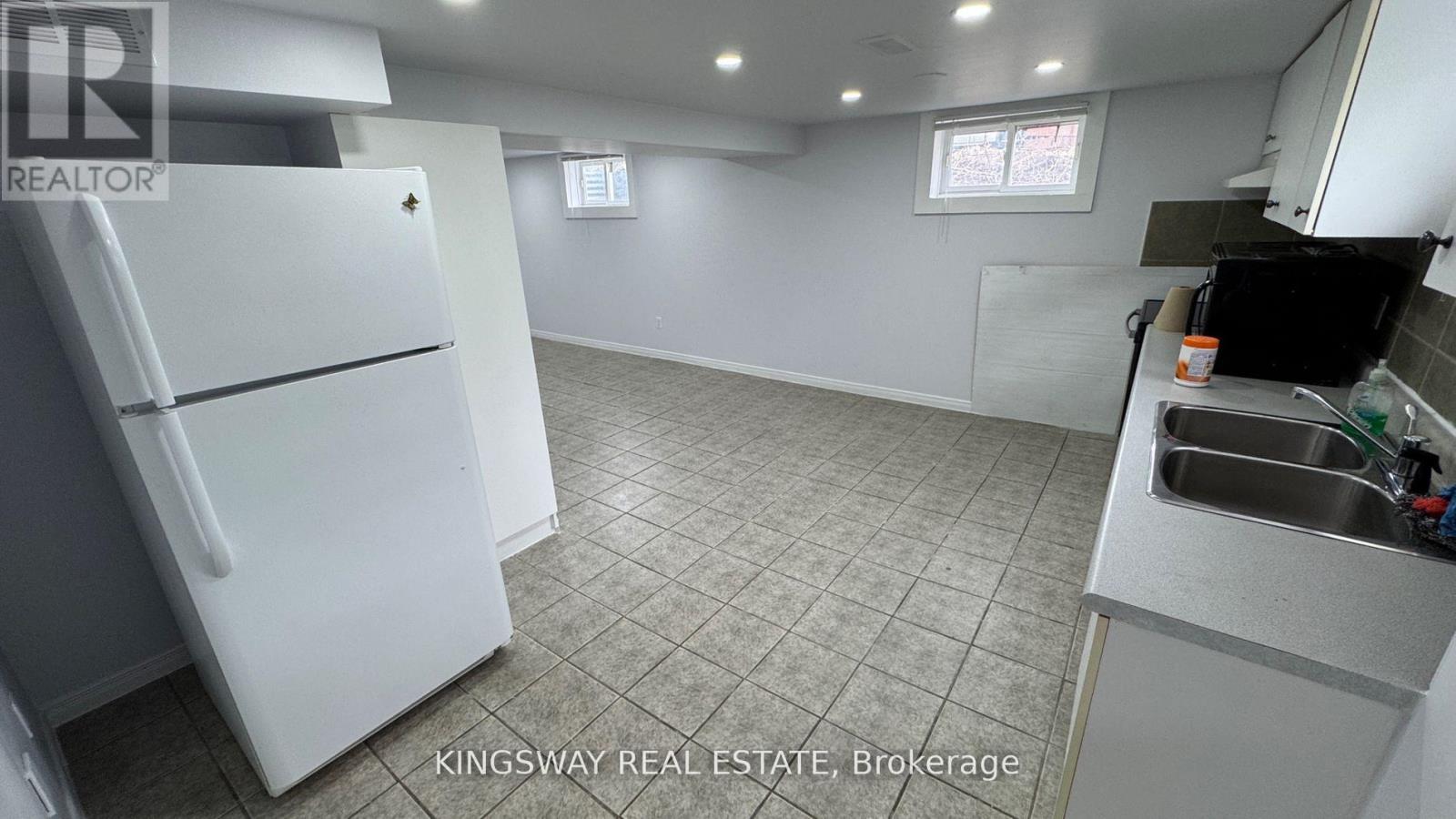 A kitchen with a white fridge and a sink.
