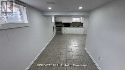 A kitchen area with white cabinets and a tiled floor.