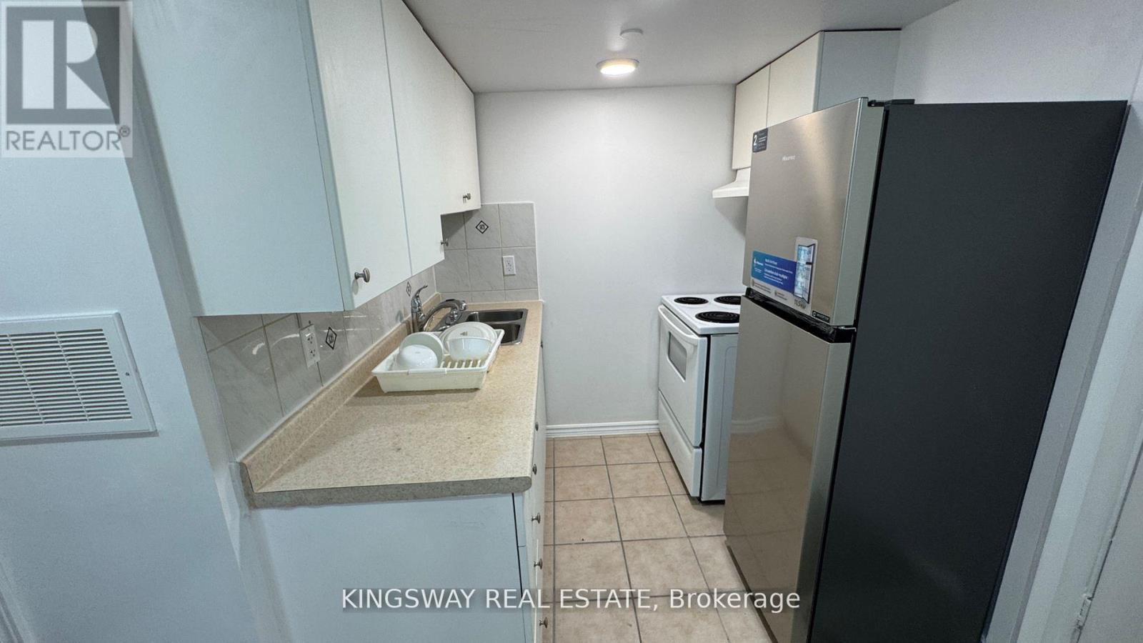 A kitchen with a refrigerator, dishwasher, and microwave.