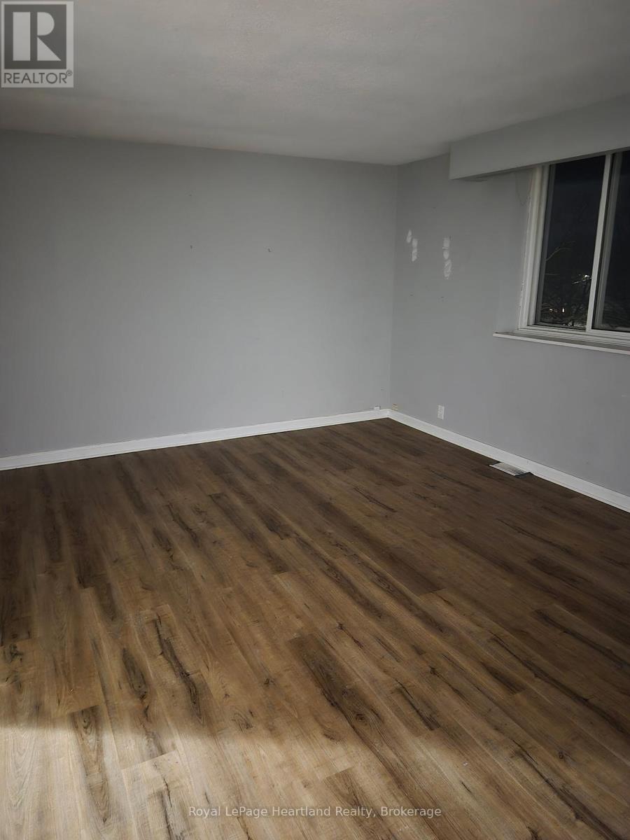 A room with wooden flooring and a window.