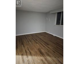 A room with wooden flooring and a window.