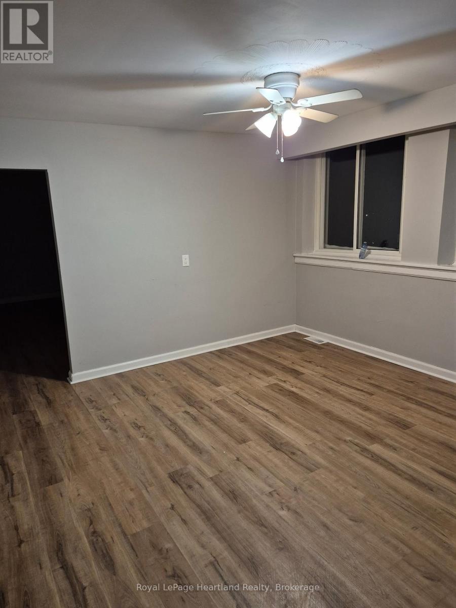 A room with wooden flooring and a ceiling fan.