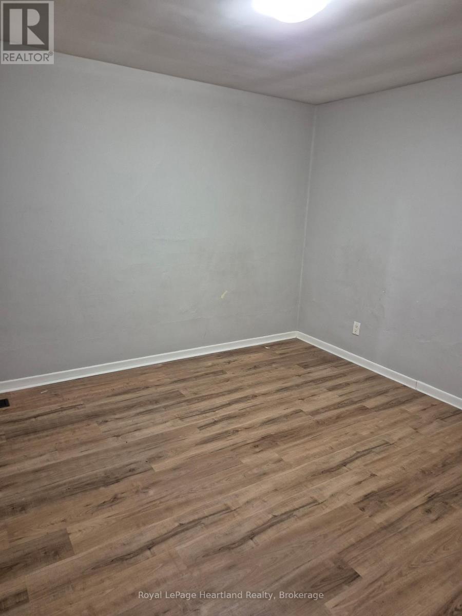 A room with wooden flooring and white walls.
