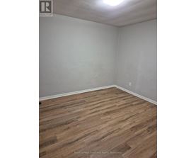 A room with wooden flooring and white walls.