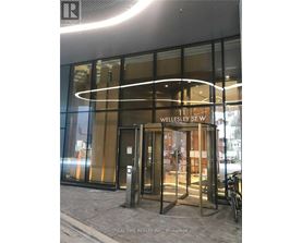 The entrance to a building with a glass door and a sign that reads "11 Wellesley St W".