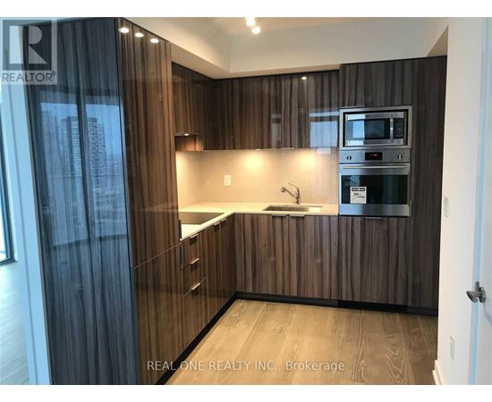A modern kitchen with wooden cabinets and a stainless steel oven.