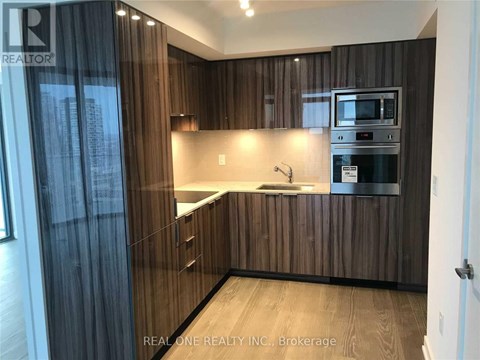 A modern kitchen with wooden cabinets and a stainless steel oven.