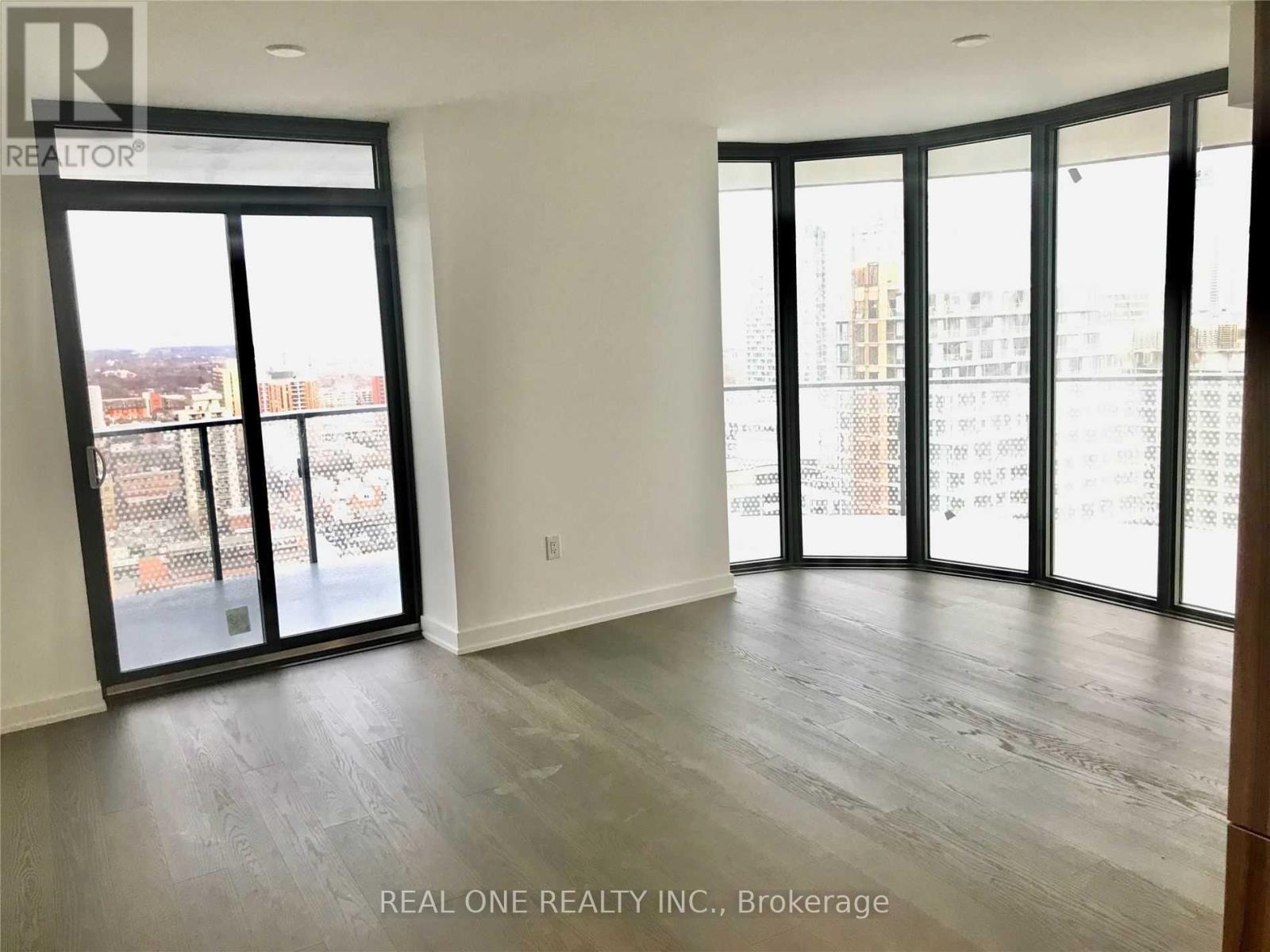 A spacious room with large windows and sliding glass doors.