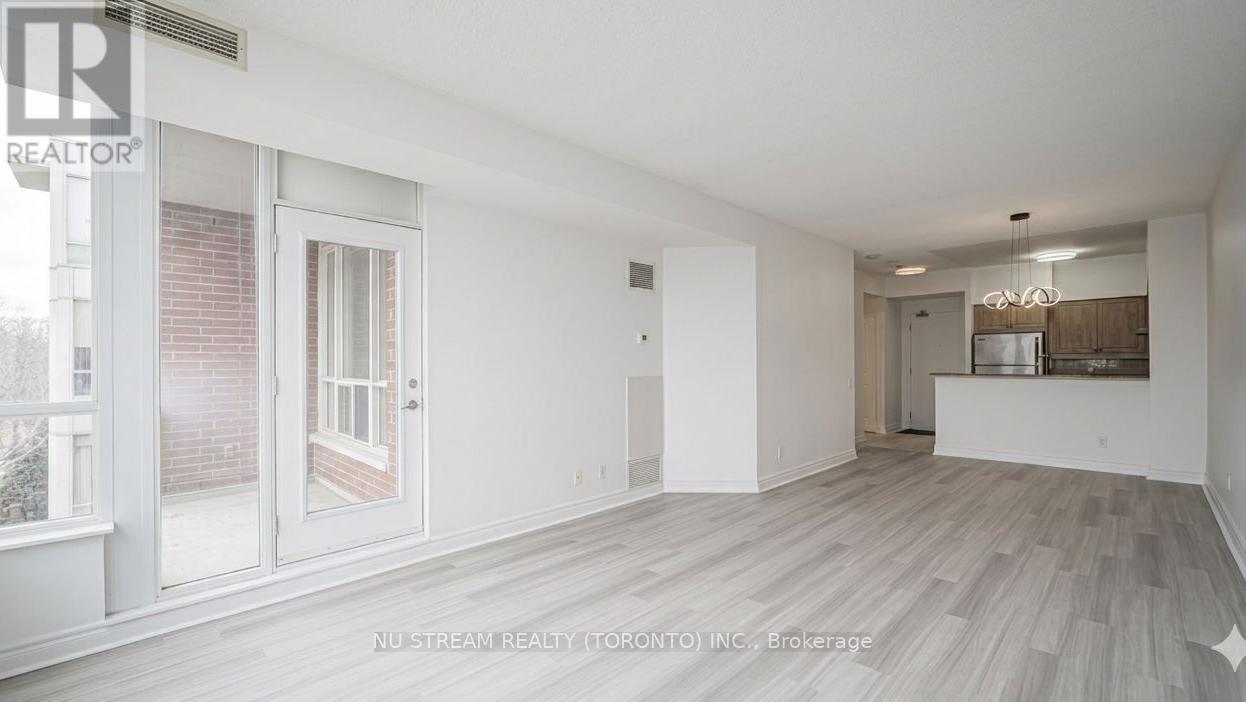 A spacious room with a sliding glass door and a view of a brick building outside.