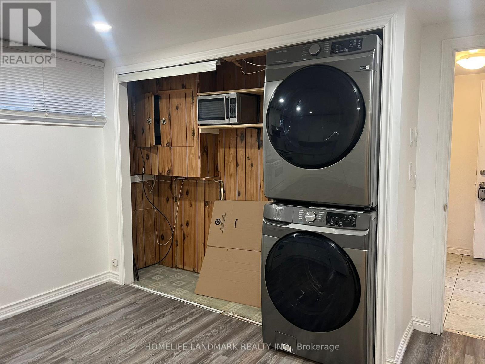 A room with a washer and dryer stacked on top of each other.
