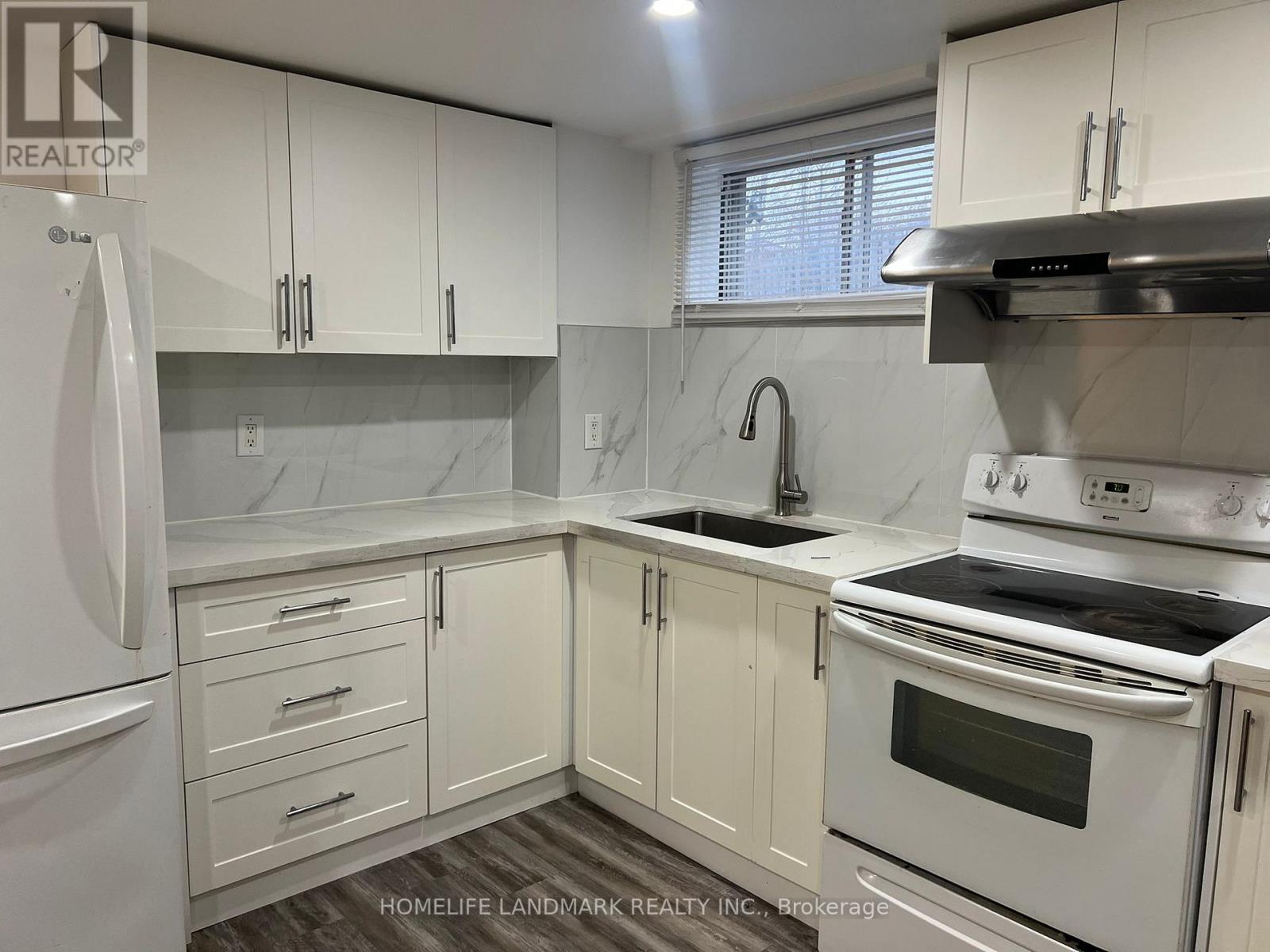 A kitchen with white cabinets and appliances.