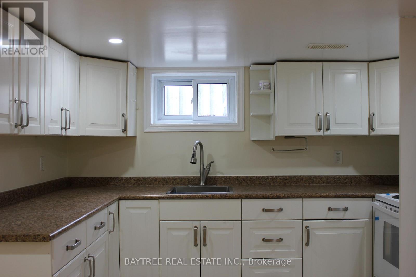 A kitchen with white cabinets and a granite countertop.