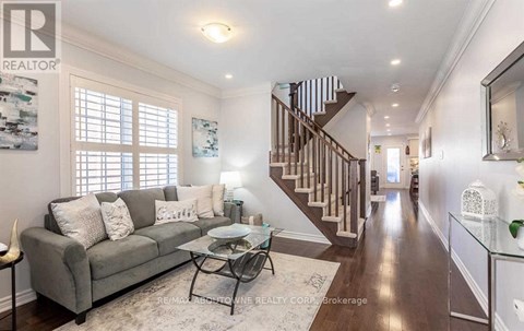 A living room with a grey couch and a glass coffee table.