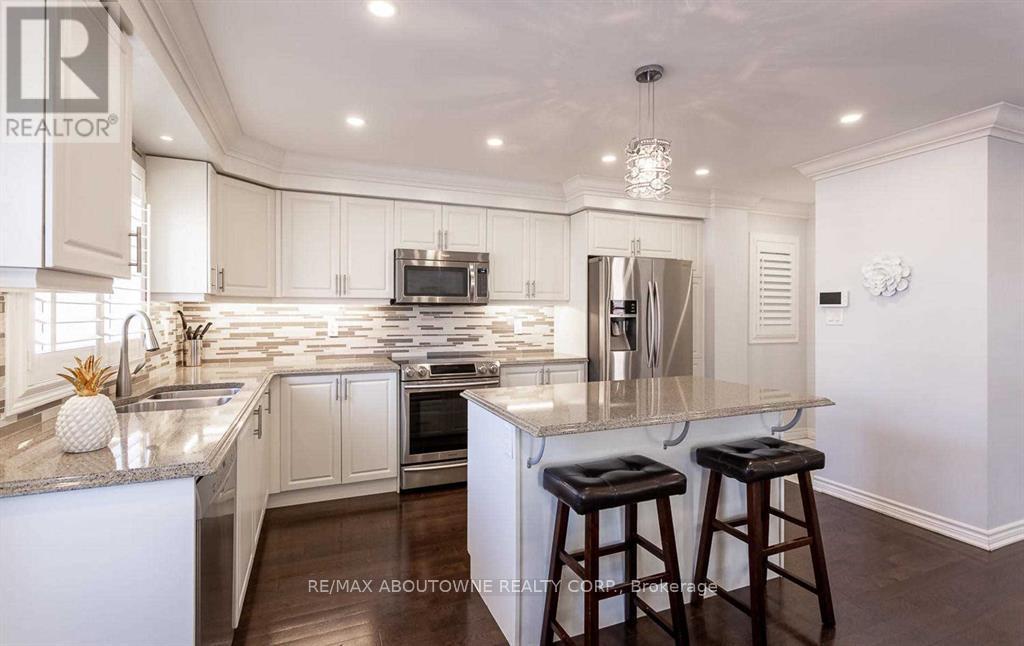 A modern kitchen with white cabinets and a marble countertop.