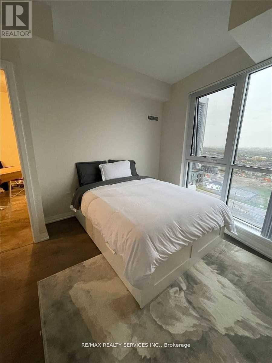 A bedroom with a large bed and a view of the city.