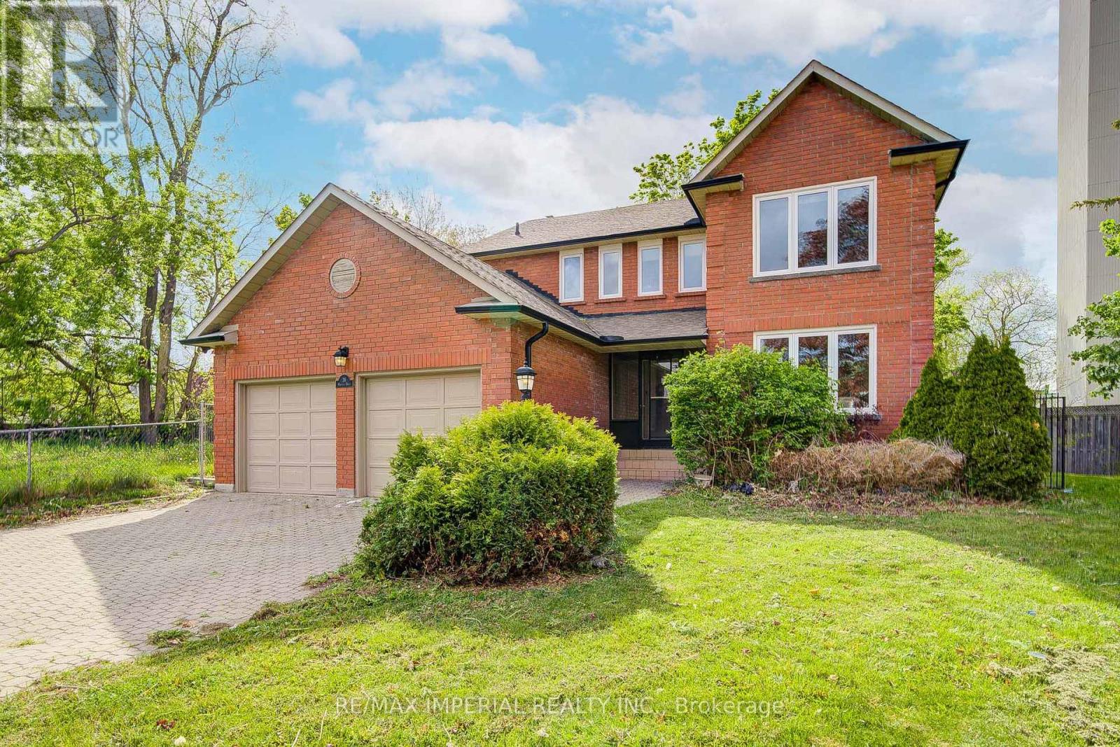 A red brick house with a garage and a driveway.