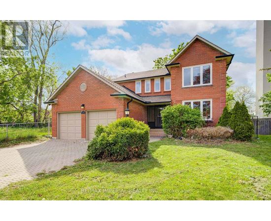 A red brick house with a garage and a driveway.